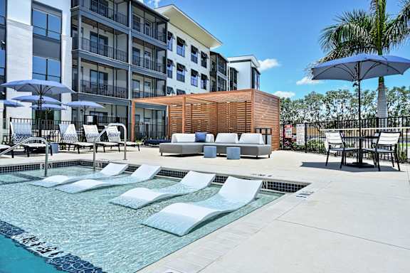 A pool area with sun loungers and a wooden structure at Ironwood Flats Apartments, Florida, 33511