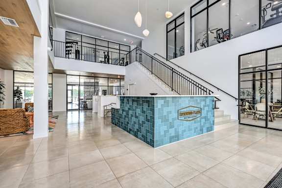 A reception area with a blue counter and a staircase at Ironwood Flats Apartments, Florida, 33511