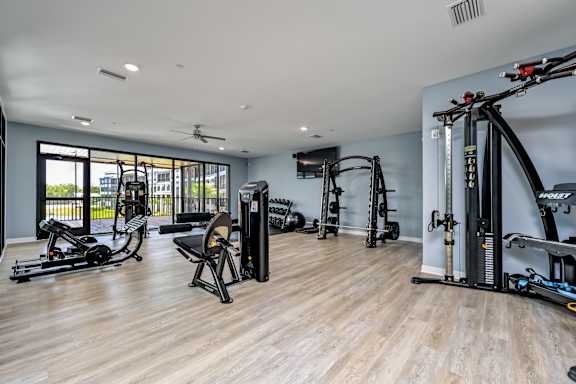 A spacious gym with a variety of equipment including a rowing machine, a stationary bike, and a treadmill at Ironwood Flats Apartments, Brandon, Florida