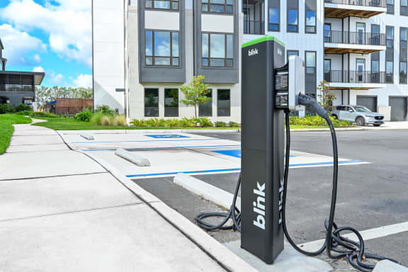 a black and green electric car charger on a sidewalk in front of a building at Ironwood Flats, Florida