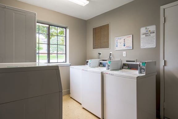 a laundry room with four washers and dryers at Stone Ridge Apartments, Wixom