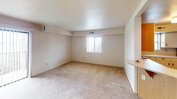 An enlarged living room with a window and sliding glass door at Liberty Mills Apartments, Fort Wayne