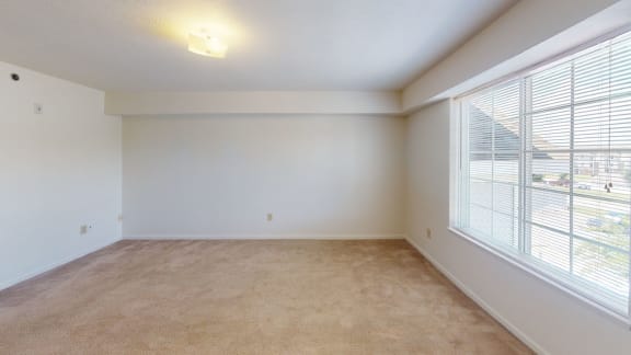 an empty living room with a large window and carpet at Limestone Creek Apartment Homes, Madison, AL, 35756