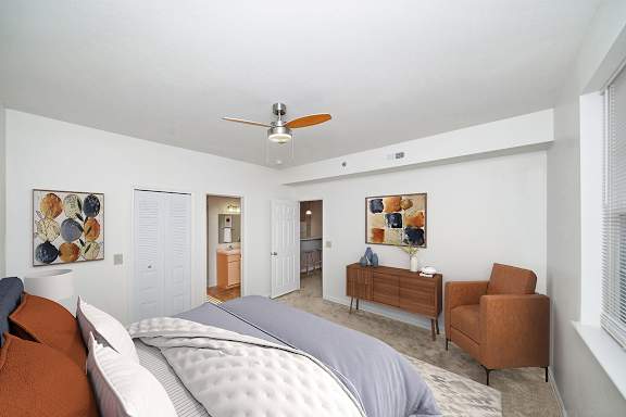 a bedroom with a ceiling fan and a doorway to an attached bath at Limestone Creek Apartment Homes, Madison, AL