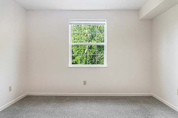 A bedroom with a window and a carpeted floor at Limestone Creek Apartment Homes, Madison, AL