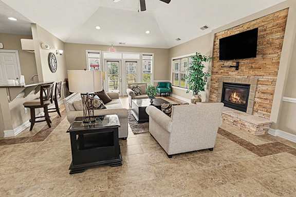 A community building with a fireplace and a flat screen TV mounted on the wall at Limestone Creek Apartment Homes, 35756