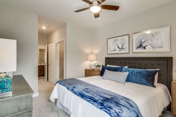 a bedroom with a large bed and a ceiling fan at Montgomery Place Apartments, Montgomery, IL, 60538