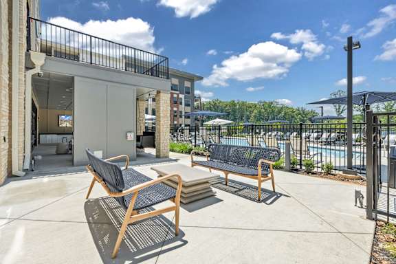 A patio with two chairs and a table at Luxe 360 on Centerpointe Apartments, Virginia