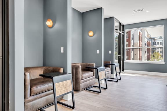 A row of brown leather chairs are lined up in a hallway at Luxe 360 on Centerpointe Apartments, Midlothian