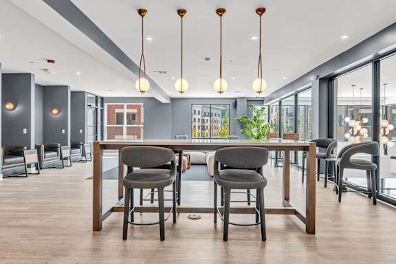 A modern dining area with a long table and chairs at Luxe 360 on Centerpointe Apartments, Midlothian, 23114