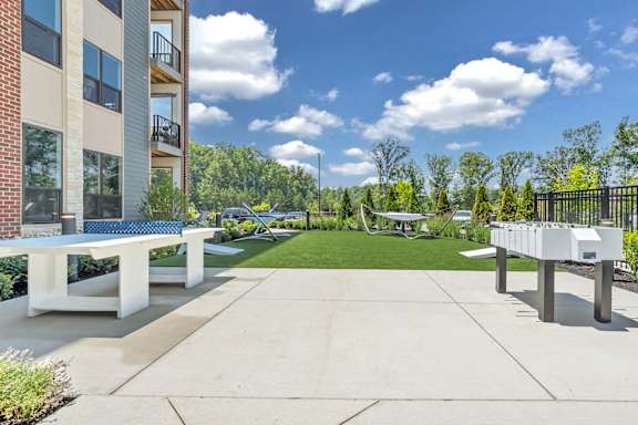 A sunny day at a residential complex with a white bench and a concrete path at Luxe 360 on Centerpointe Apartments, Midlothian