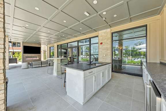 A modern kitchen with a large island and a view of the backyard at Luxe 360 on Centerpointe Apartments, Midlothian, 23114