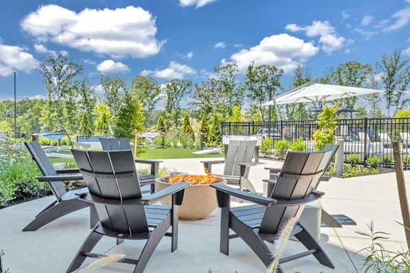 A patio with a table and chairs is set up for outdoor dining at Luxe 360 on Centerpointe Apartments, Midlothian, VA