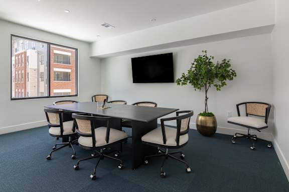 A conference room with a long table and chairs at Luxe 360 on Centerpointe Apartments, Midlothian, Virginia