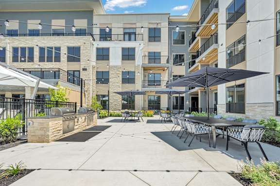 A sunny day at a modern apartment complex with a patio area at Luxe 360 on Centerpointe Apartments, Midlothian, Virginia