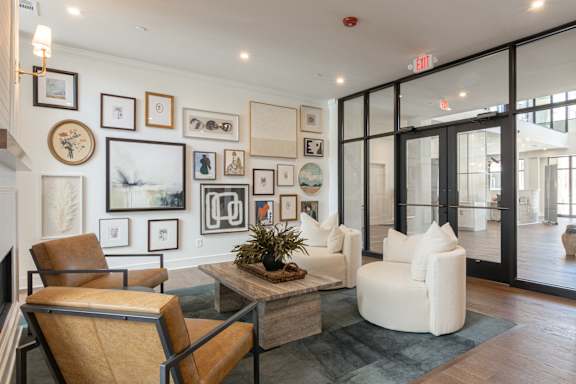 A living room with a brown chair and a plant on the coffee table at Luxe 360 on Centerpointe Apartments, Virginia