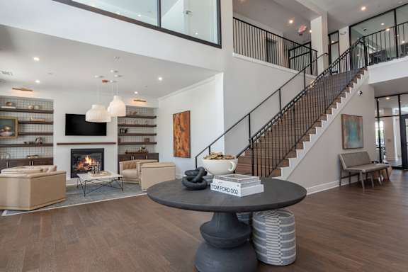 A living room with a fireplace and a staircase at Luxe 360 on Centerpointe Apartments, Midlothian, VA, 23114