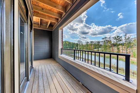 A balcony with a view of a river and trees at Luxe 360 on Centerpointe Apartments, Virginia
