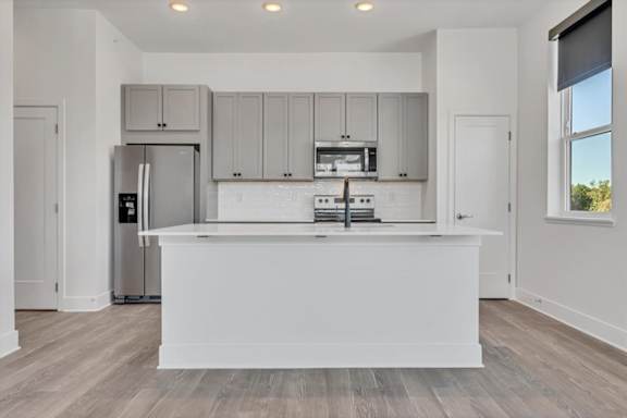 A modern kitchen with a white island and stainless steel appliances at Luxe 360 on Centerpointe Apartments, Midlothian, Virginia