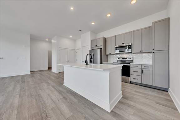 A modern kitchen with a white island and wooden floors at Luxe 360 on Centerpointe Apartments, Virginia, 23114