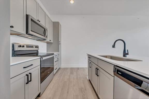 A kitchen with white cabinets and stainless steel appliances at Luxe 360 on Centerpointe Apartments, Midlothian