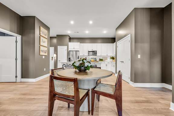 A modern kitchen with a dining table set for two at Luxe 360 on Centerpointe Apartments, Midlothian, 23114