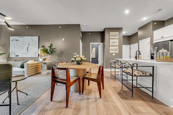 A modern dining room with a wooden table and chairs at Luxe 360 on Centerpointe Apartments, Midlothian, VA, 23114
