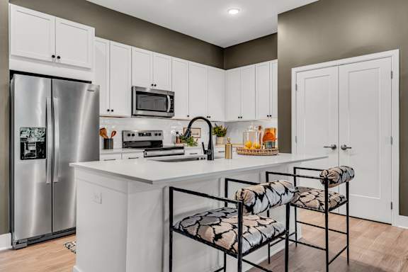 A kitchen with white cabinets and a stainless steel refrigerator at Luxe 360 on Centerpointe Apartments, Midlothian, VA