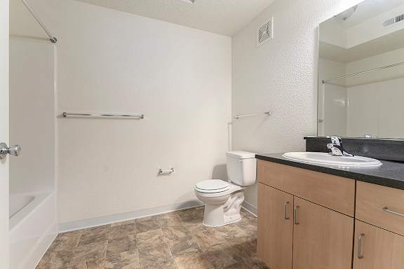 A bathroom with a toilet, sink, and a bathtub/shower at Lynbrook Apartments and Townhomes, Elkhorn, NE, 68022