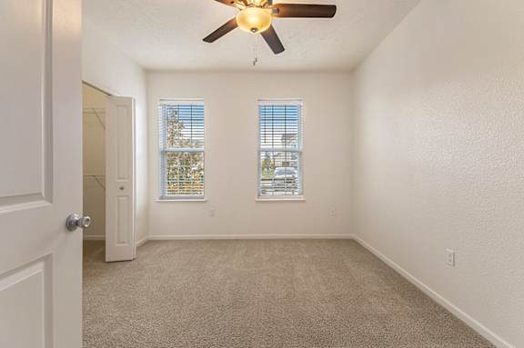 A bedroom with a ceiling fan and two windows at Lynbrook Apartments and Townhomes, Elkhorn, NE, 68022