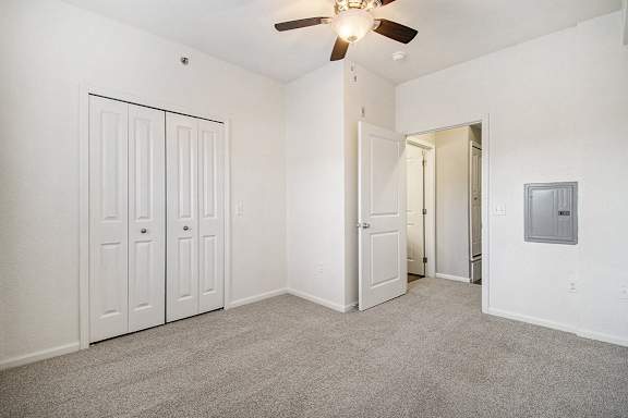 A spacious bedroom with a ceiling fan and a large closet A spacious bedroom with a ceiling fan and a large closet at Lynbrook Apartments and Townhomes, Elkhorn, NE, 68022