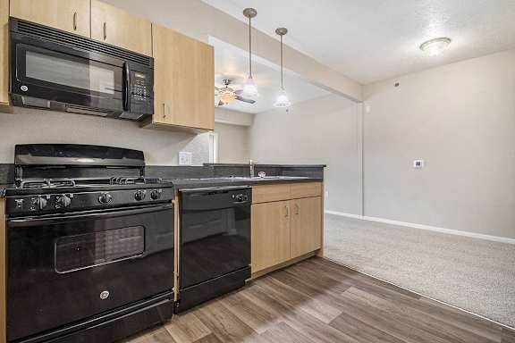 A kitchen with black appliances and wooden cabinets A kitchen with black appliances and wooden cabinets at Lynbrook Apartments and Townhomes, Elkhorn, NE, 68022