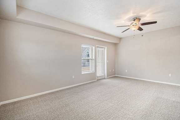 An enlarged living room with a ceiling fan and access to a private patio An enlarged living room with a ceiling fan and access to a private patio at Lynbrook Apartments and Townhomes, Elkhorn, NE, 68022
