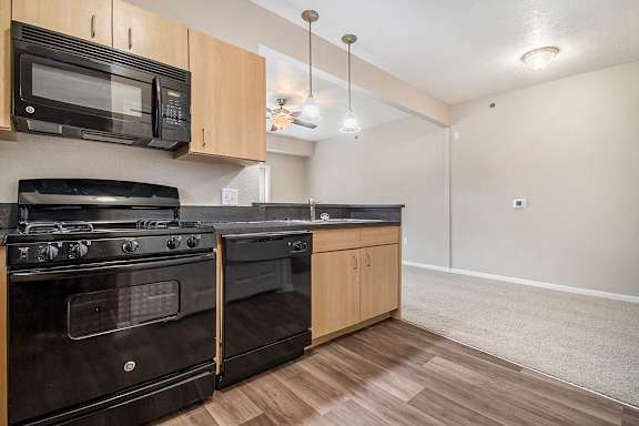 A kitchen with black appliances and wooden cabinets at Lynbrook Apartments and Townhomes, Elkhorn, NE, 68022