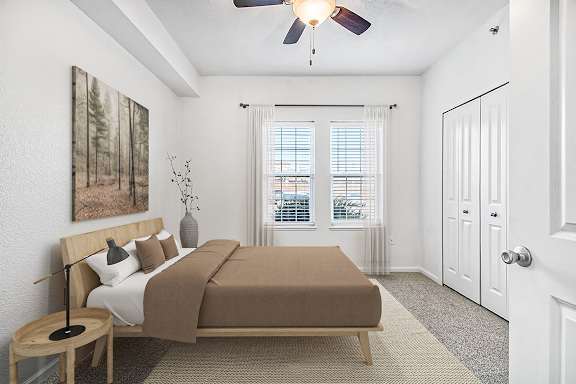 A bedroom with a ceiling fan and two windows at Lynbrook Apartments and Townhomes, Elkhorn, NE, 68022