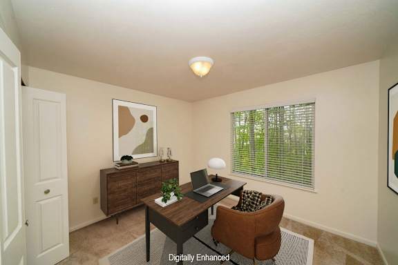 A bedroom with a brown desk with a laptop at Lynbrook Apartments and Townhomes, Elkhorn, 68022