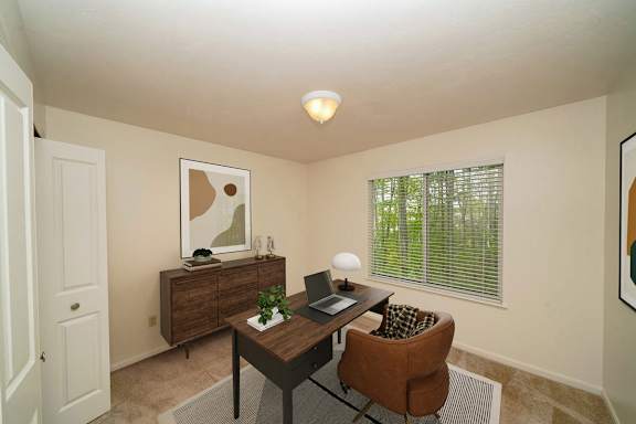 A bedroom with a brown desk with a laptop at Lynbrook Apartments and Townhomes, Elkhorn, 68022