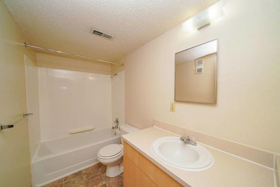 A bathroom with a toilet, sink, and shower.