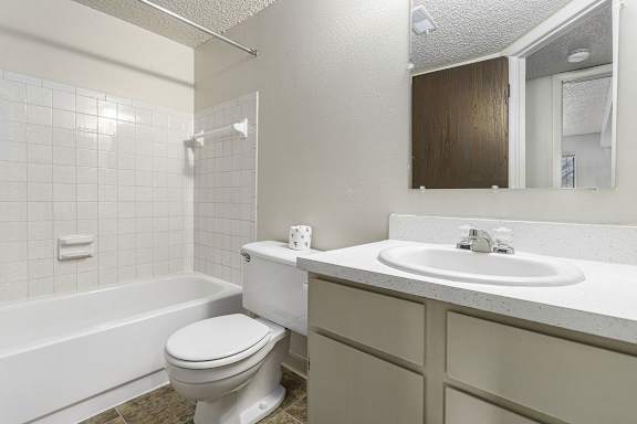 A white toilet sits next to a white sink in a bathroom.