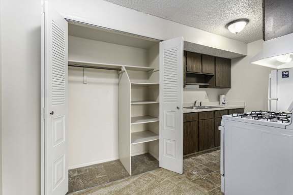 A kitchen with a white fridge and cabinets.