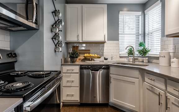 A modern kitchen with a stove, sink, and cabinets