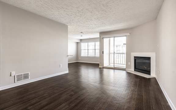 A spacious living room with wood flooring and a fireplace