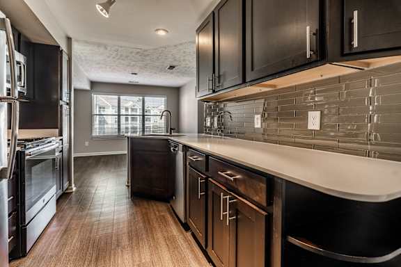 A modern kitchen with dark wood cabinets and stainless steel appliances