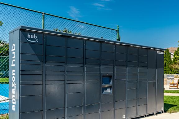 A large Amazon hub building is shown with a fence in the background