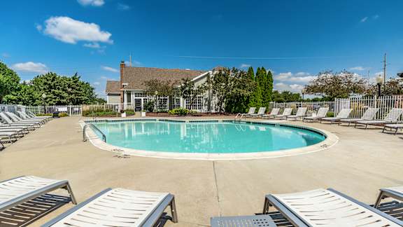 A large outdoor swimming pool surrounded by sun loungers