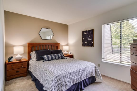 a bedroom with a large window and a large bed  at Sycamore Creek Apartments, Lake Orion
