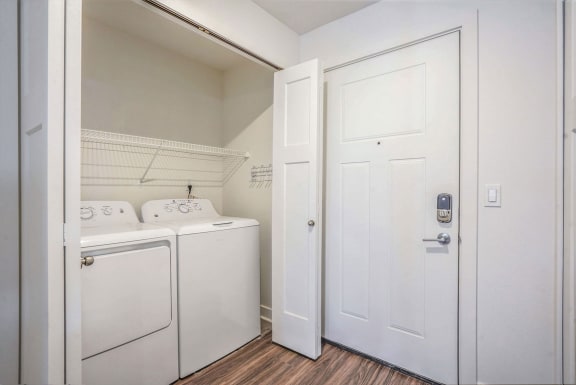 a laundry room with a washer and dryer and a white door at Meadowbrooke Apartment Homes, Grand Rapids, 49512