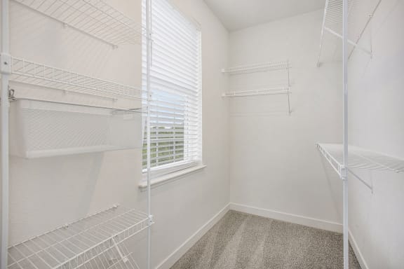 a closet with white walls and a window in a room with white closets at Meadowbrooke Apartment Homes, Michigan, 49512