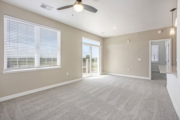 an empty living room with a ceiling fan and a window at Meadowbrooke Apartment Homes, Grand Rapids, MI