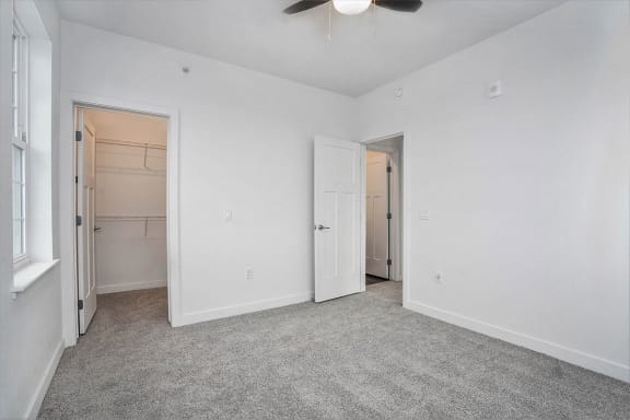a bedroom with a closet and a ceiling fan at Meadowbrooke Apartment Homes, Grand Rapids, MI